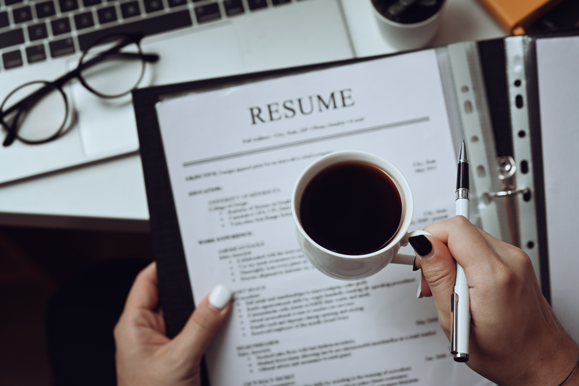 Close up view human resource manager reading CV resumes of job candidate.